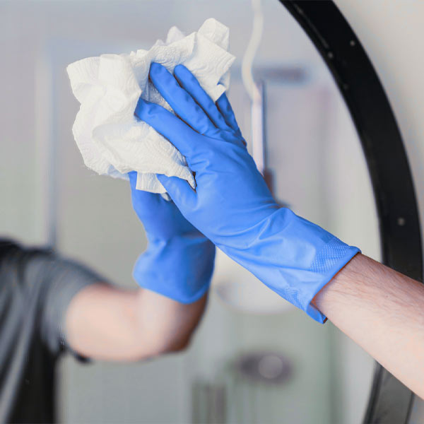 En person putsar en spegel