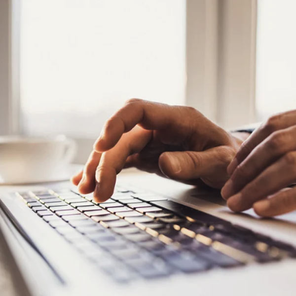 En person skriver på en laptop